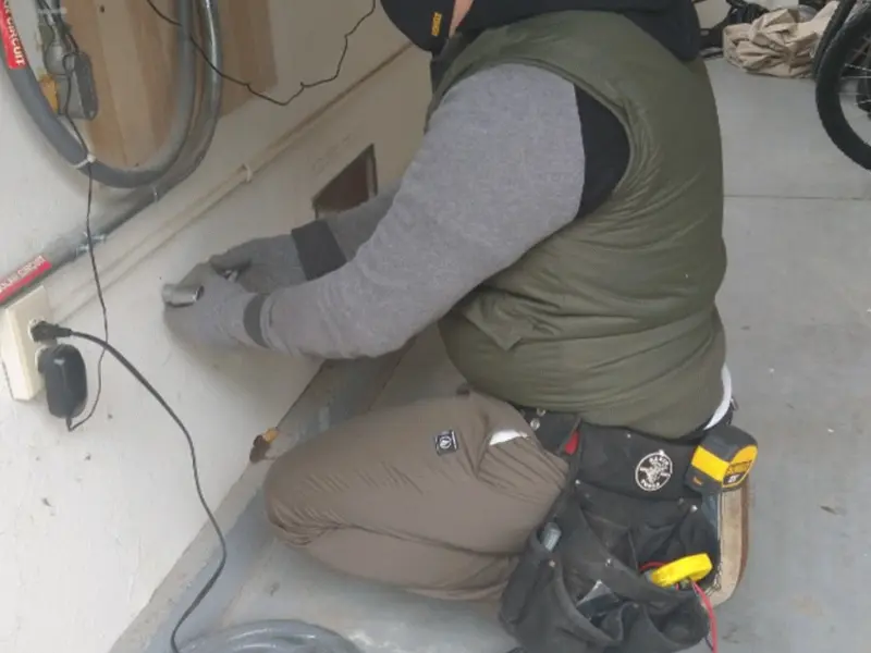 Electrician performing outlet wiring in a Coleman garage